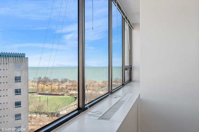 interior space featuring a water view and expansive windows