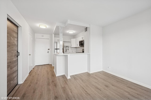 kitchen featuring light countertops, light wood finished floors, visible vents, and appliances with stainless steel finishes