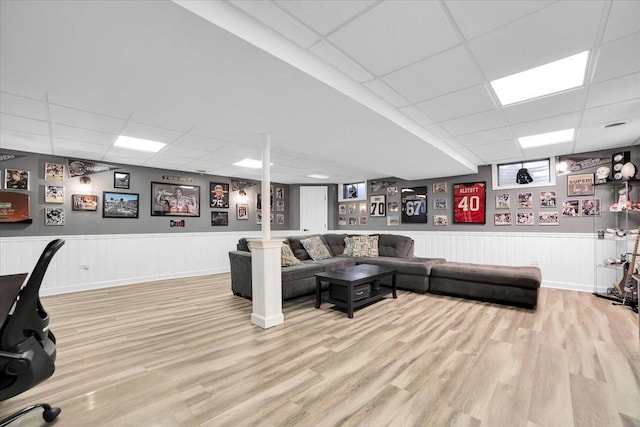 interior space featuring a paneled ceiling, wood finished floors, and wainscoting