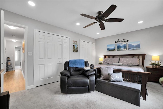 bedroom featuring multiple closets, recessed lighting, light colored carpet, and ceiling fan