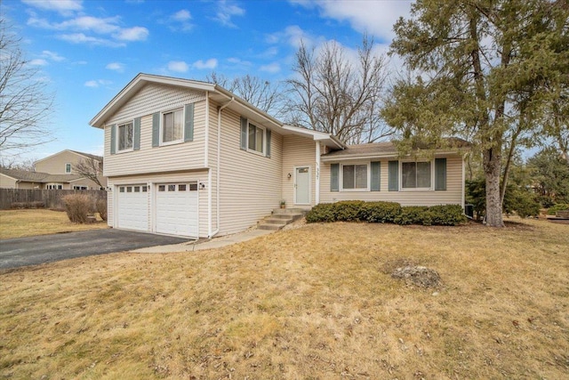 split level home with a garage, a front yard, and driveway