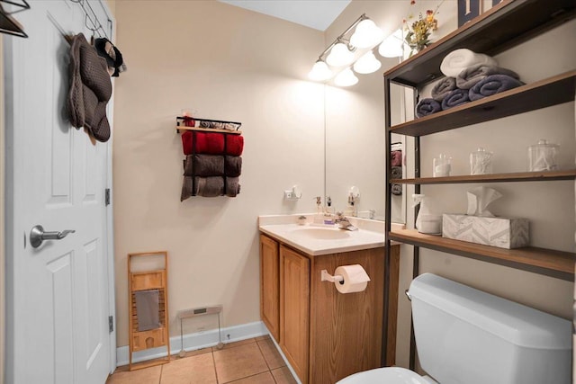 half bath with tile patterned flooring, baseboards, vanity, and toilet