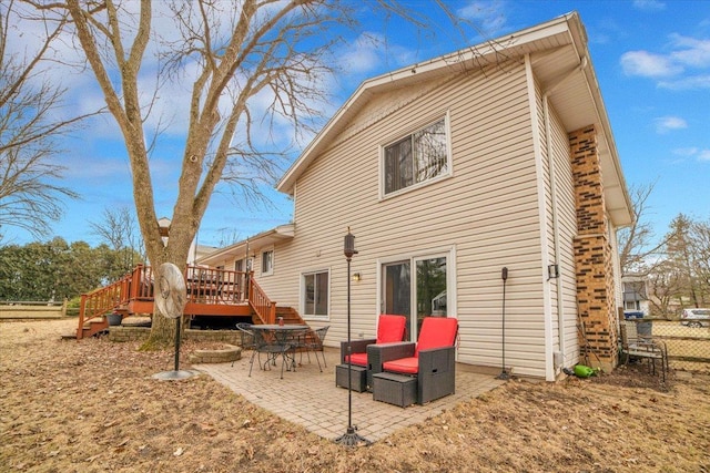 back of property with a patio, a wooden deck, and fence