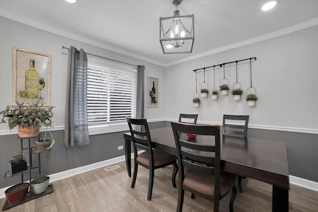 dining area with a chandelier, crown molding, baseboards, and wood finished floors