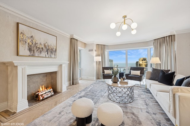 living room featuring a notable chandelier, crown molding, visible vents, a lit fireplace, and baseboards