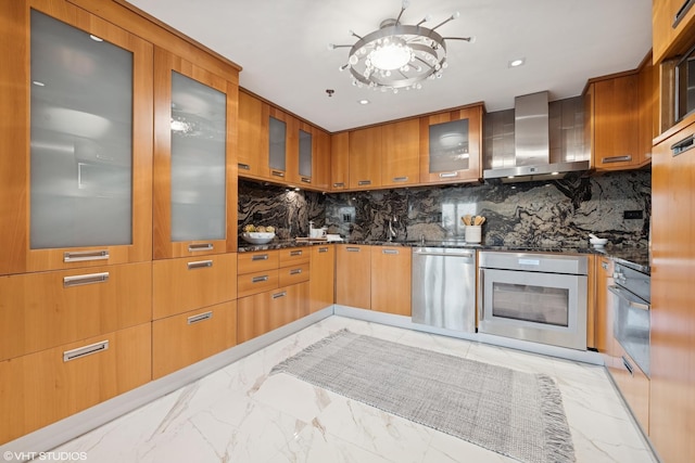 kitchen with marble finish floor, stainless steel appliances, glass insert cabinets, modern cabinets, and wall chimney exhaust hood