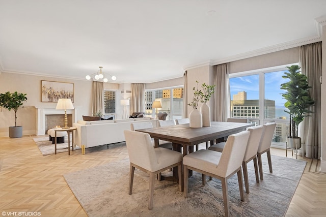 dining space with a warm lit fireplace, a notable chandelier, crown molding, and baseboards