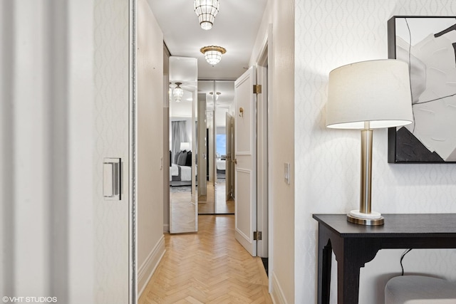 hallway with baseboards and wallpapered walls