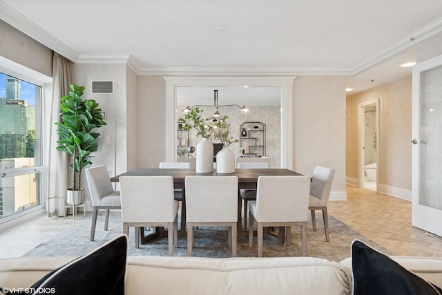 dining space with visible vents, crown molding, and baseboards