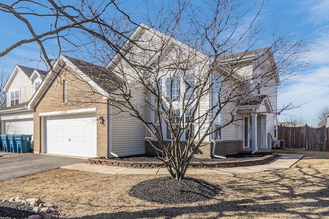 view of front of property featuring brick siding, driveway, central AC unit, and fence