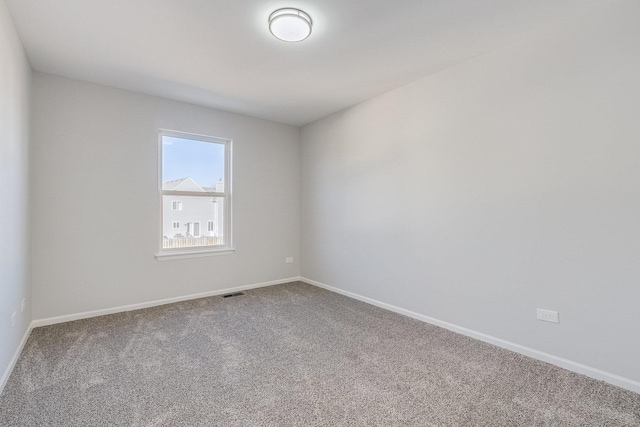 carpeted empty room featuring baseboards and visible vents