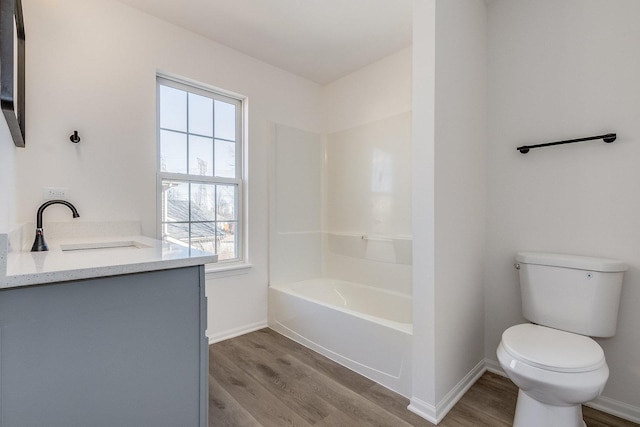 bathroom featuring baseboards, vanity, toilet, and wood finished floors