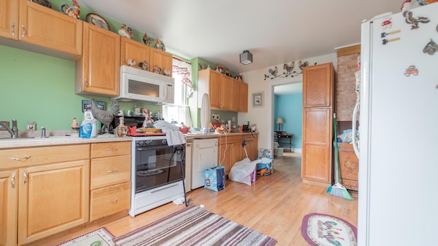 kitchen featuring light brown cabinets, white appliances, a sink, light wood-style floors, and light countertops