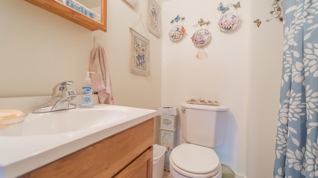 bathroom featuring toilet, a shower with shower curtain, and vanity