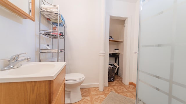 bathroom with baseboards, vanity, and toilet