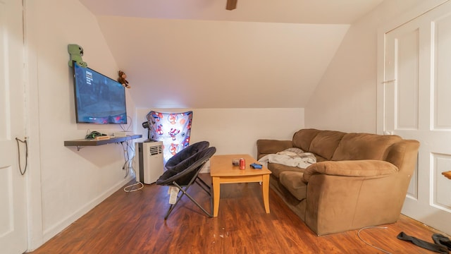 living area featuring lofted ceiling, baseboards, and wood finished floors