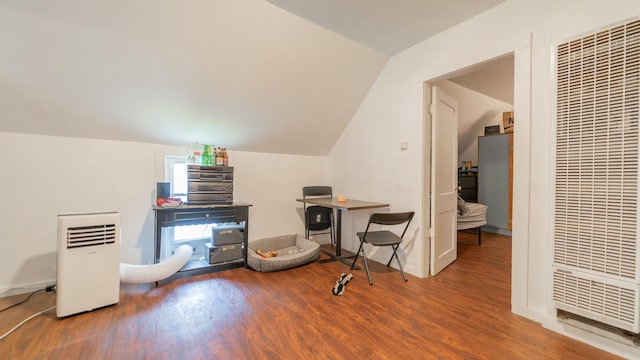 interior space featuring lofted ceiling, a heating unit, and wood finished floors