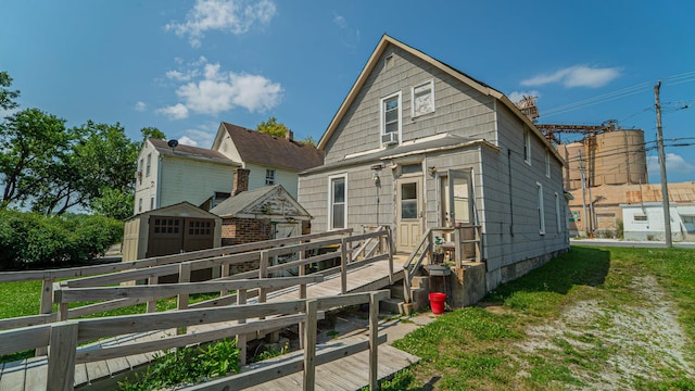 back of house featuring an outdoor structure, a wooden deck, and a shed