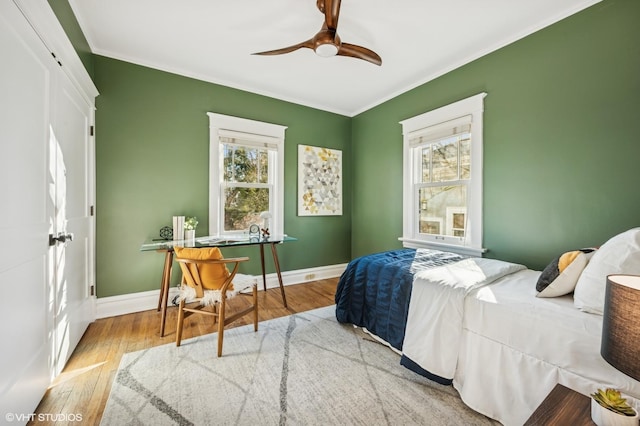 bedroom featuring crown molding, wood finished floors, and baseboards