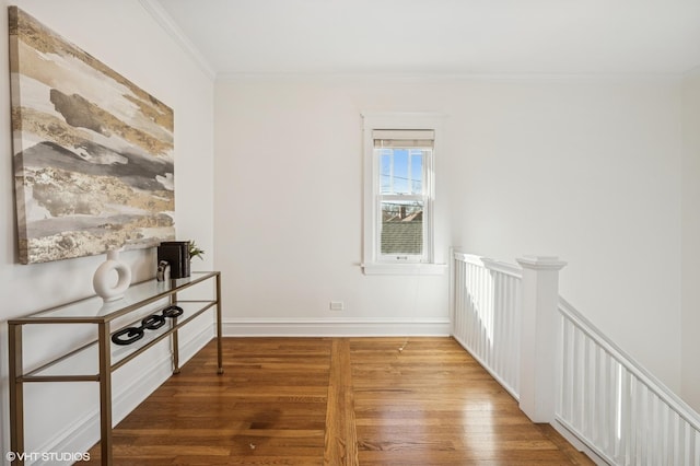 interior space featuring crown molding, wood finished floors, and baseboards