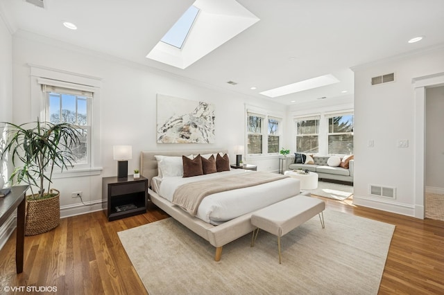 bedroom with visible vents, crown molding, and wood finished floors