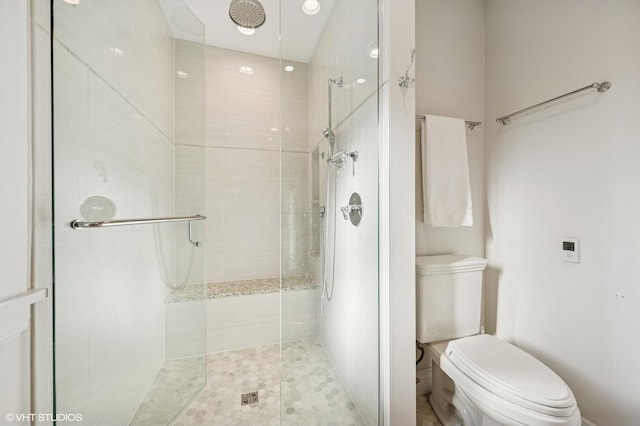 bathroom featuring toilet and tiled shower