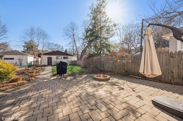 view of patio with an outbuilding, fence, area for grilling, and an outdoor fire pit