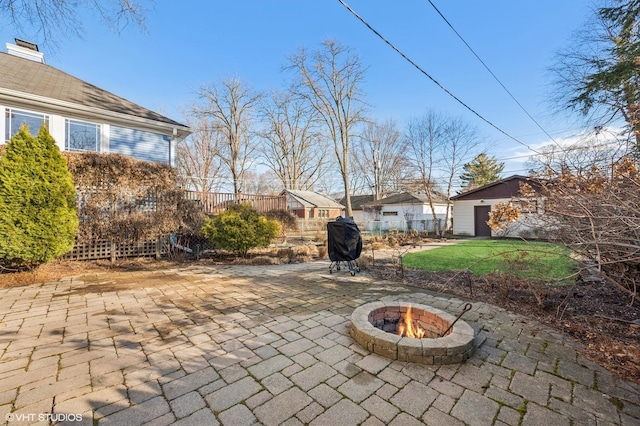 view of patio with an outdoor structure and a fire pit