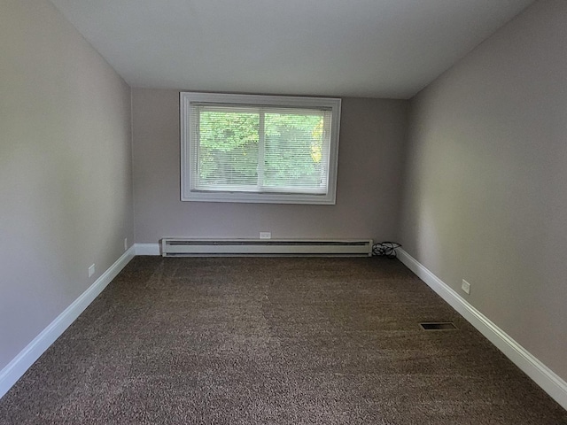 spare room with dark colored carpet and baseboards