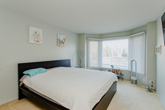 bedroom with light colored carpet and baseboards