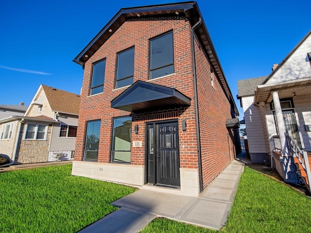 view of front of property with brick siding and a front yard