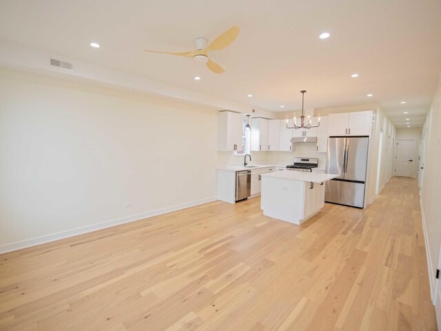 kitchen with stainless steel appliances, light countertops, visible vents, white cabinets, and a sink