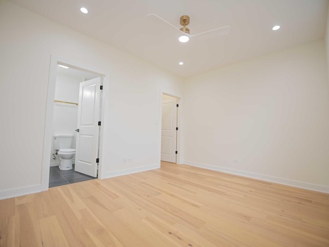 unfurnished bedroom with ensuite bath, baseboards, wood finished floors, and recessed lighting