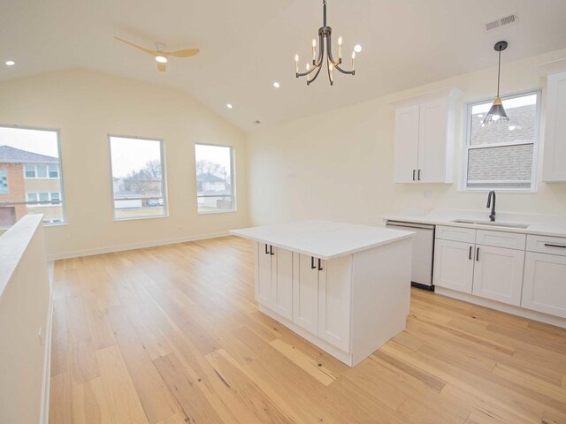 kitchen with a kitchen island, a sink, visible vents, light wood-type flooring, and dishwasher