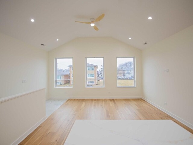 interior space with lofted ceiling, baseboards, plenty of natural light, and light wood finished floors