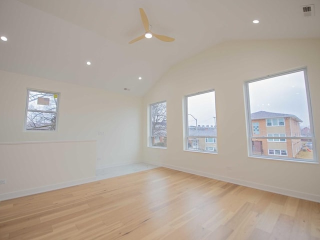 unfurnished room with a wealth of natural light, lofted ceiling, light wood-type flooring, and visible vents