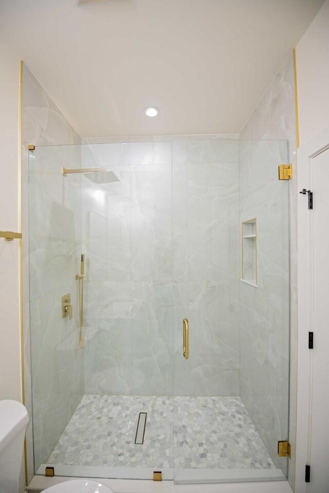 bathroom featuring a stall shower and toilet