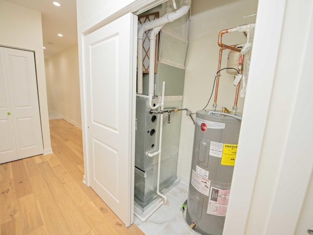 utility room featuring water heater and heating unit