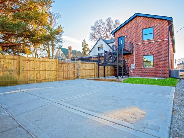 back of house with brick siding, fence, and stairs