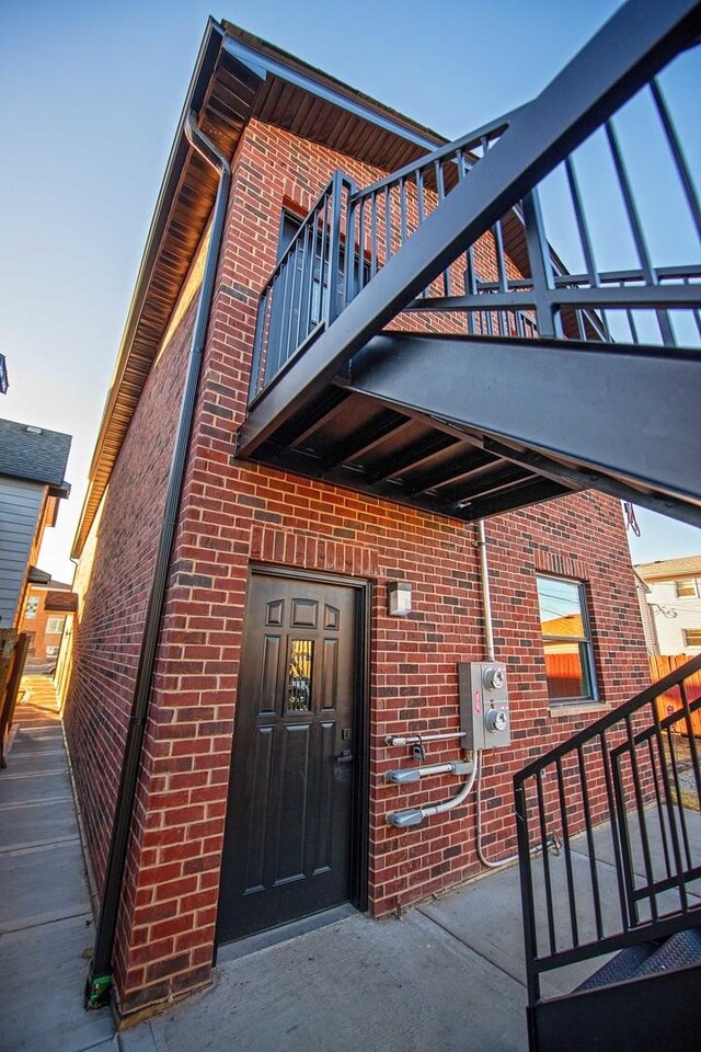 entrance to property with a balcony and brick siding