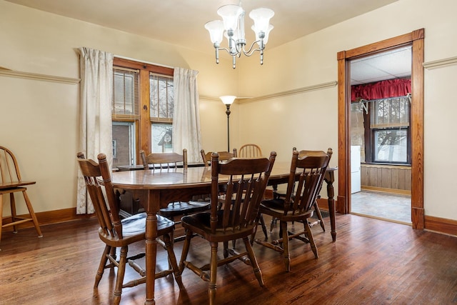 dining room with baseboards, wood finished floors, and a notable chandelier