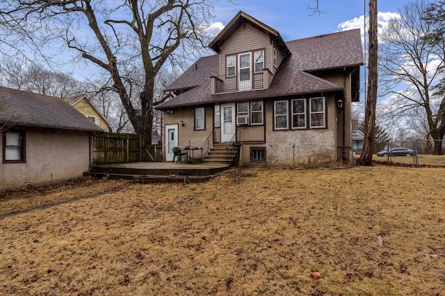 back of property featuring entry steps, roof with shingles, fence, and stucco siding