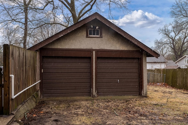 detached garage featuring fence