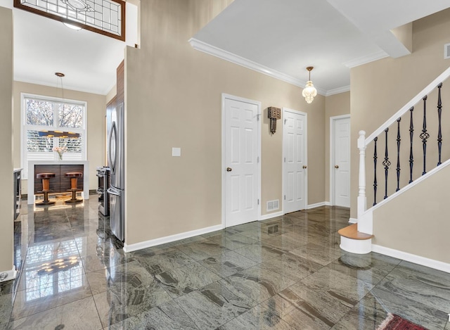 foyer entrance with visible vents, baseboards, stairs, marble finish floor, and crown molding