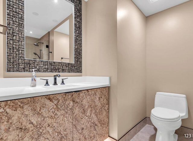 full bathroom featuring tiled shower, vanity, toilet, and tile patterned floors