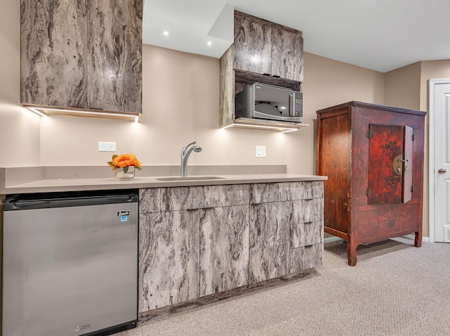 kitchen featuring light carpet, appliances with stainless steel finishes, modern cabinets, and a sink