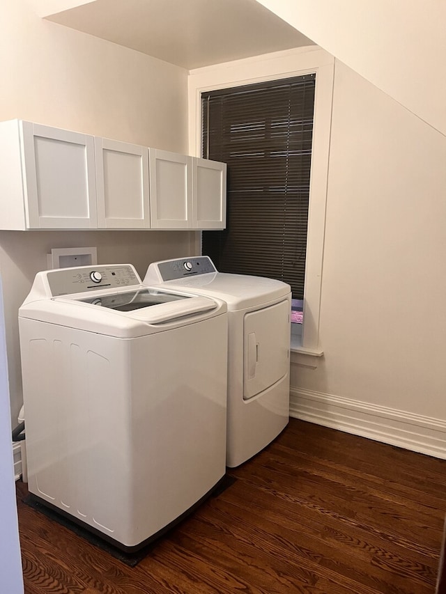 clothes washing area with dark wood-style floors, cabinet space, washer and clothes dryer, and baseboards