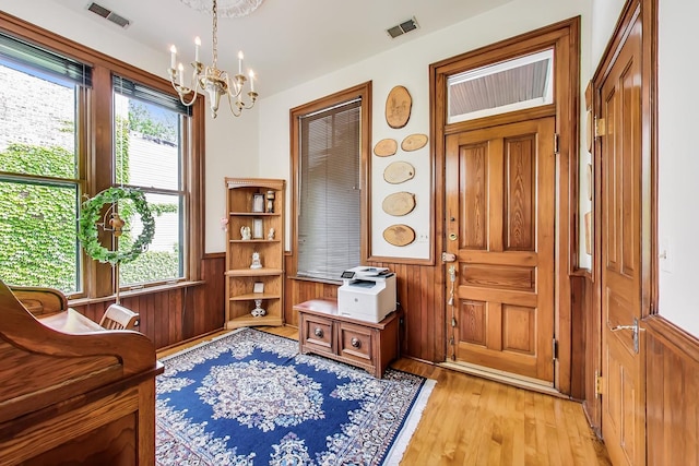 sitting room featuring a wainscoted wall, visible vents, light wood-style floors, and wood walls