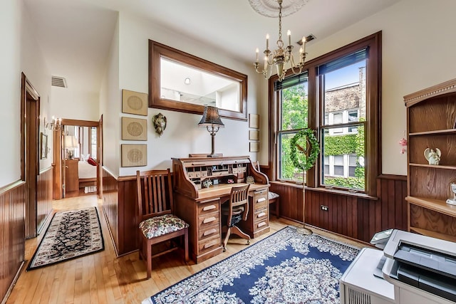 living area featuring a notable chandelier, wood walls, visible vents, wainscoting, and wood-type flooring