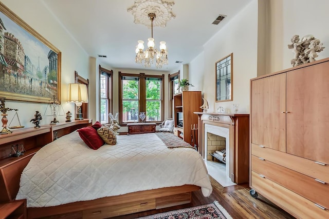 bedroom featuring visible vents, an inviting chandelier, and wood finished floors